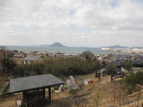 cafe 風車の丘から見下ろした瀬戸内海。ふもとの家々の屋根の向こうに港と島が見える