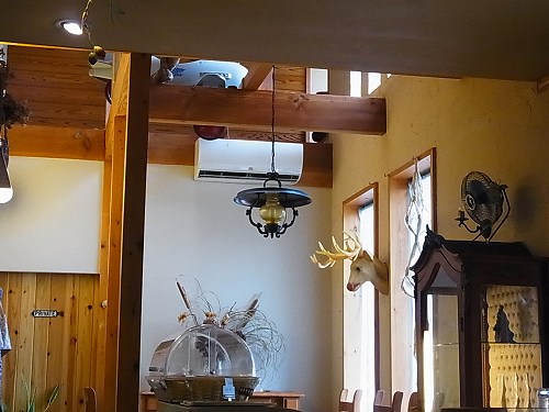 カフェジジの店内。高い天井と梁、吊り下げられたランプ、壁の鹿の飾り
