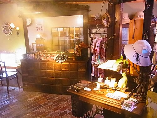 カフェジジの雑貨売り場。古い引き出しの棚と大きな鏡、帽子や小物