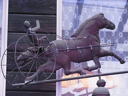 カフェジジの壁面にとりつけられた、馬車をかたどった鉄のオブジェ