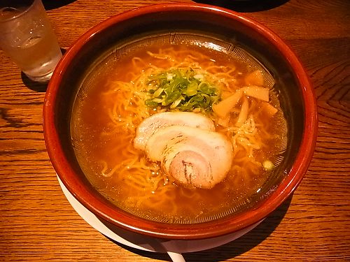 赤いどんぶりに入った、しょうゆラーメン。チャーシュー二枚とねぎ、メンマがのっている